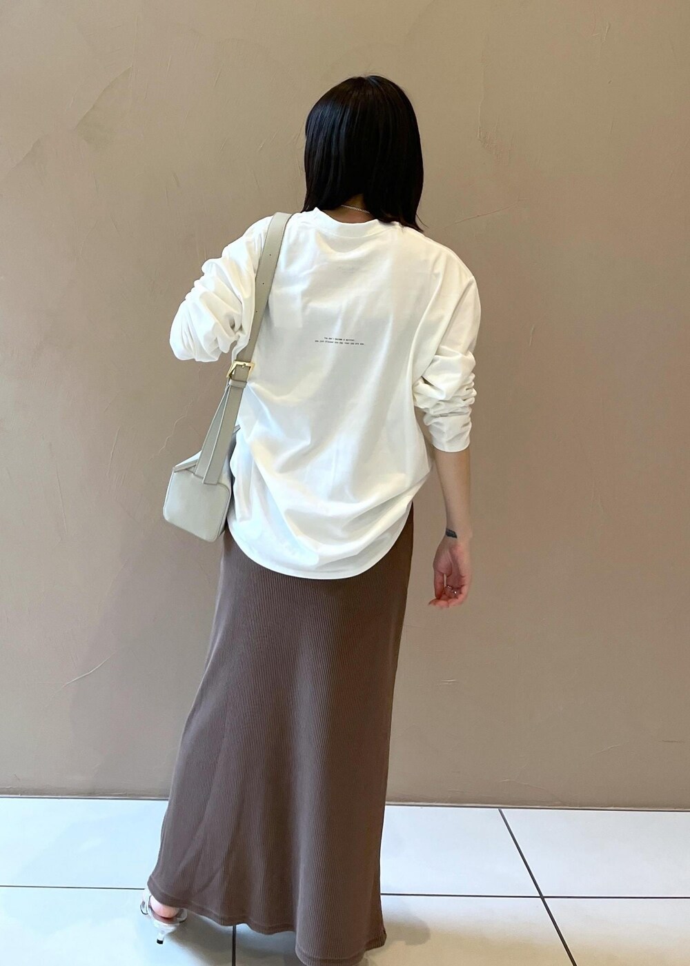 シルバー系のサンダル、ブラウン系のスカート、グレー系のショルダーバッグを着用したレディースの夏コーディネートの4枚目の写真