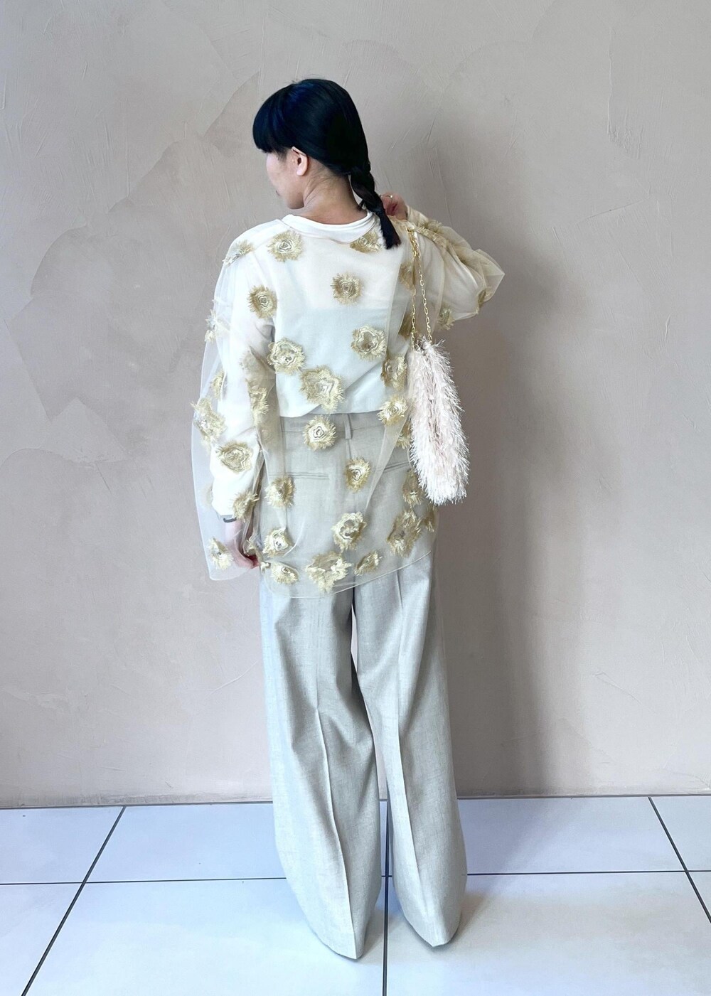 ゴールド系のTシャツ/カットソー、ホワイト系のTシャツ/カットソー、ベージュ系のスラックスを着用したレディースの冬コーディネートの3枚目の写真