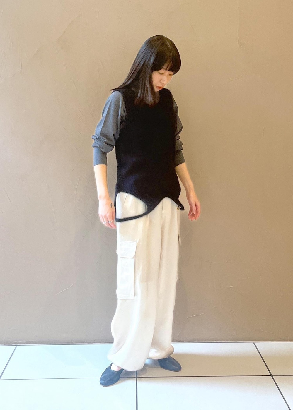 ホワイト系のカーゴパンツ、ブラック系のタンクトップ、グレー系のニット/セーターを着用したレディースの秋コーディネートの8枚目の写真