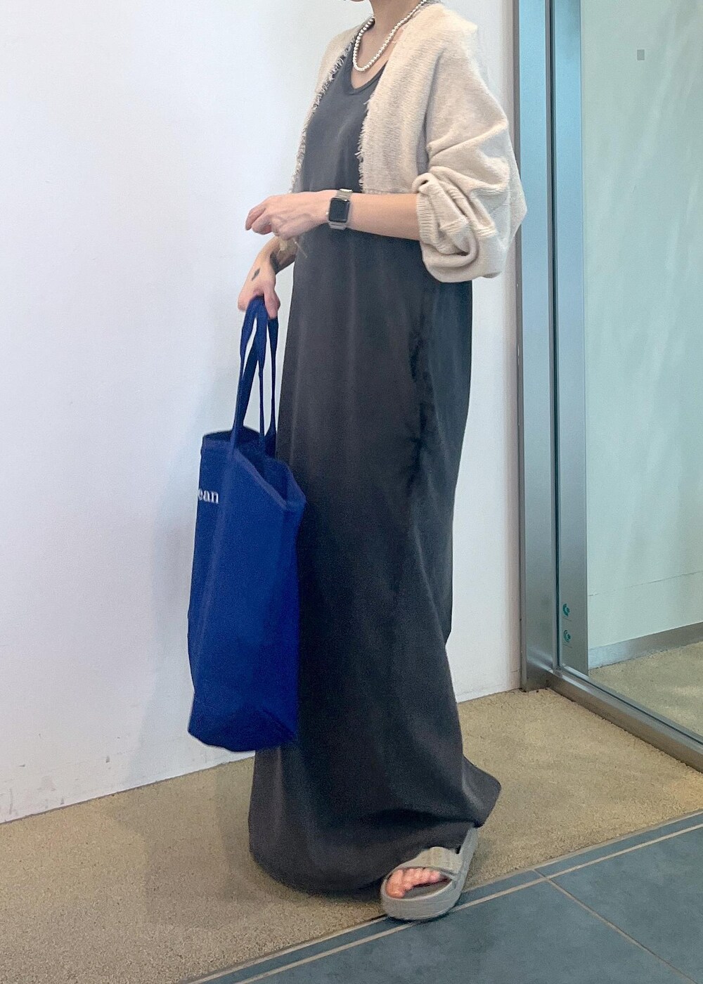 グレー系のワンピース、ホワイト系のカーディガン/ボレロを着用したレディースの夏コーディネートの5枚目の写真