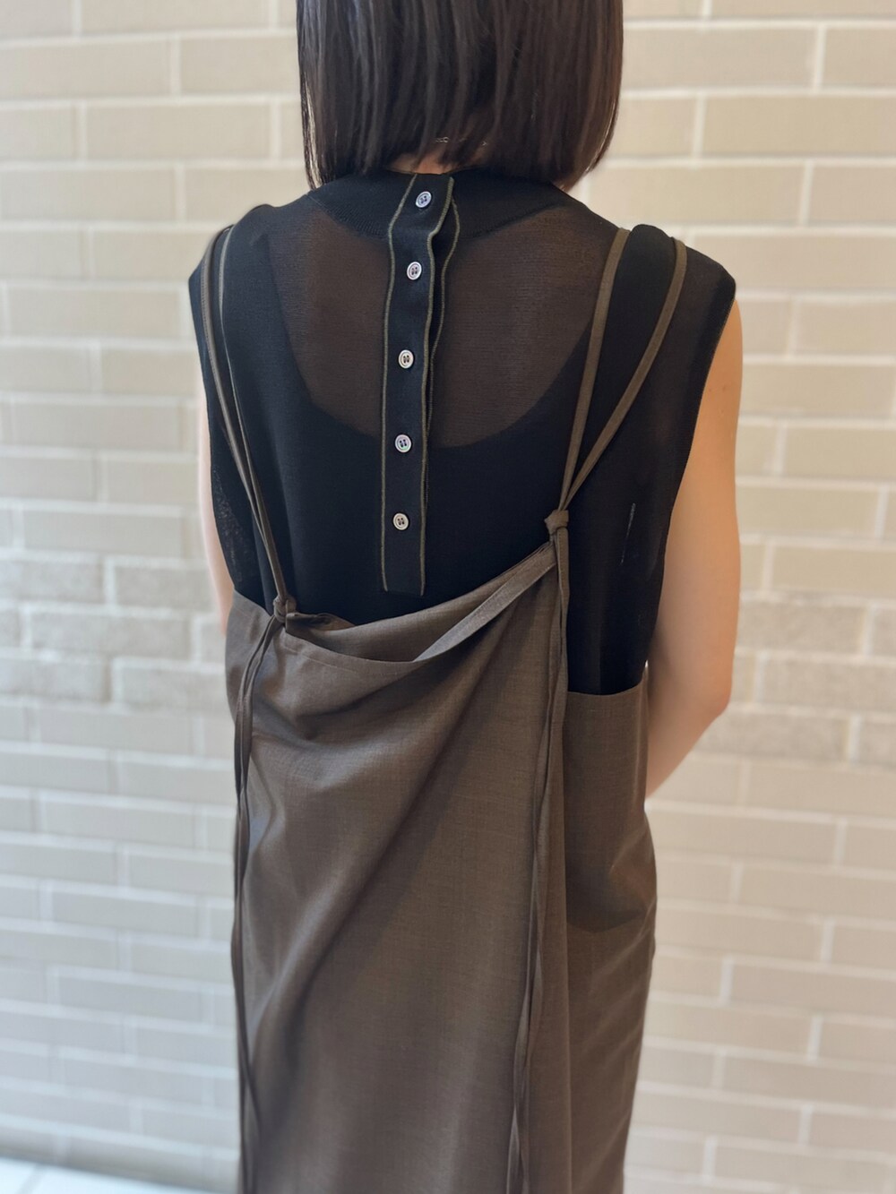 ブラウン系のワンピース、ブラック系のTシャツ/カットソー、ブラック系のサンダルを着用したレディースの夏コーディネートの4枚目の写真