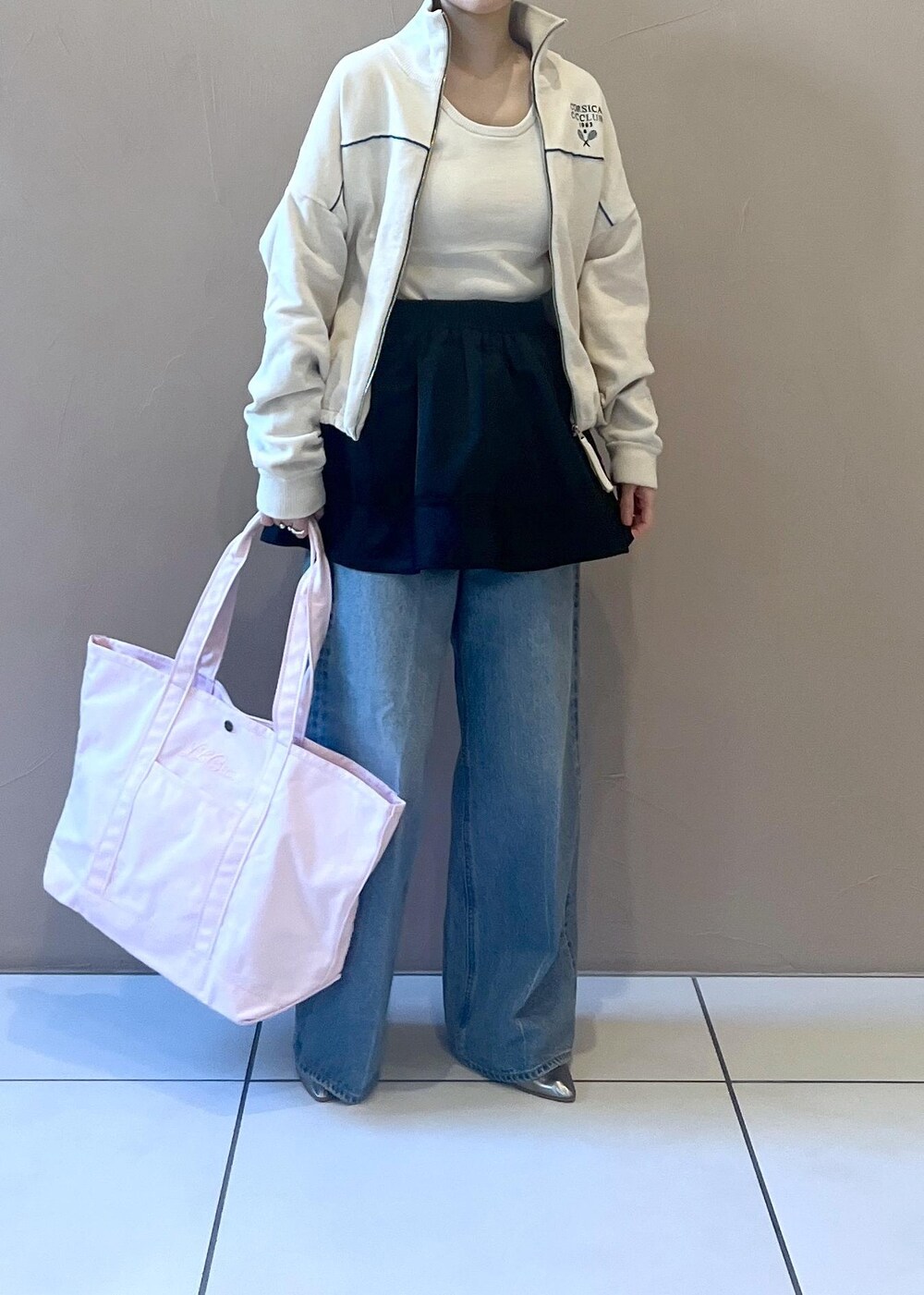 ブルー系のデニムパンツ、ブラック系のスカート、ホワイト系のタンクトップを着用したレディースの冬コーディネートの3枚目の写真