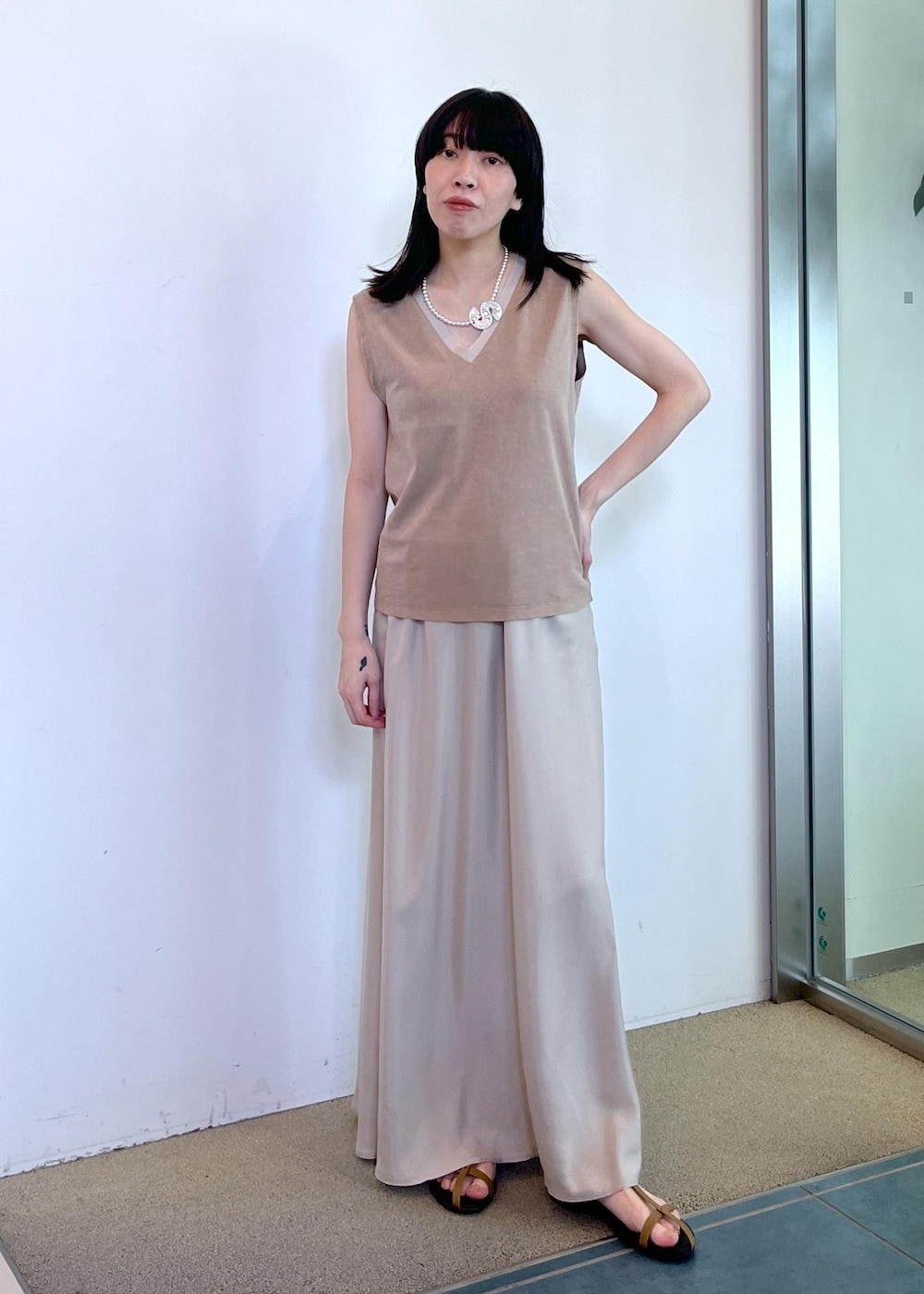 ベージュ系のスカート、ベージュ系のタンクトップ、グリーン系のストール/ショールを着用したレディースの夏コーディネートの3枚目の写真