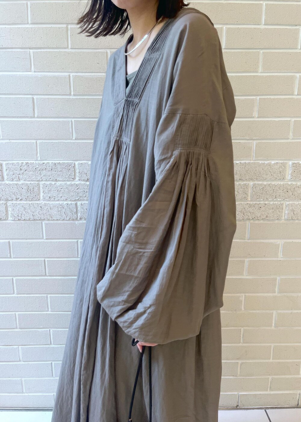 グレー系のワンピースを着用したレディースの夏コーディネートの3枚目の写真