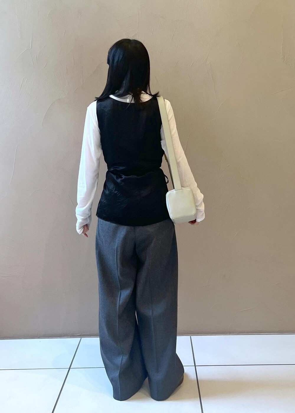 グレー系のショルダーバッグ、ブラック系のTシャツ/カットソー、グレー系のスラックスを着用したレディースの秋コーディネートの3枚目の写真