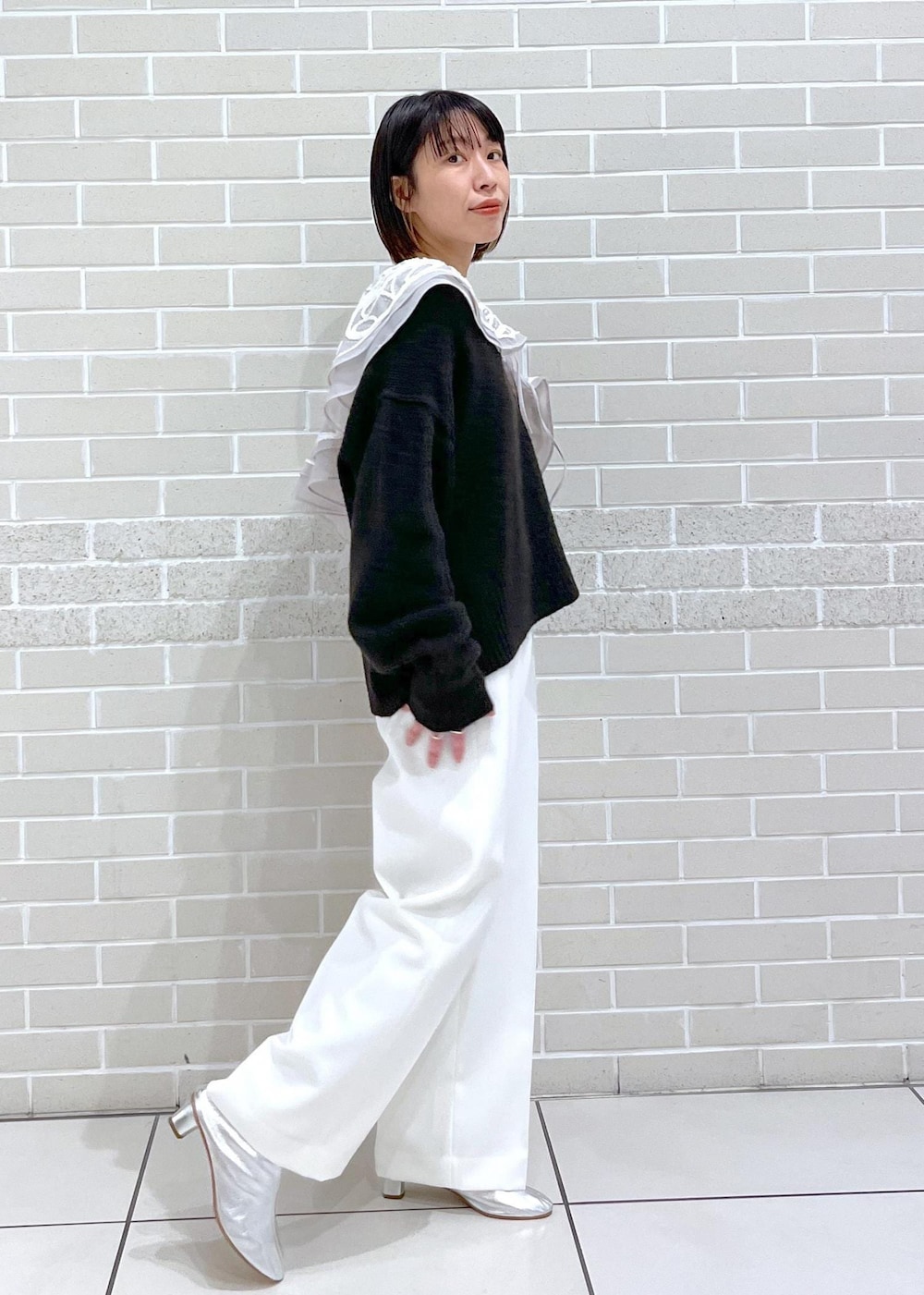 ブラウン系のニット/セーター、ホワイト系のその他パンツ、ベージュ系のストール/ショールを着用したレディースの冬コーディネートの3枚目の写真