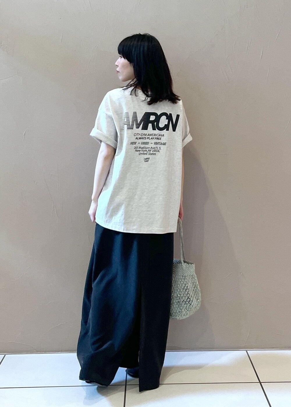 ブラック系のワンピース、ホワイト系のTシャツ/カットソー、シルバー系のトートバッグを着用したレディースの春コーディネートの4枚目の写真