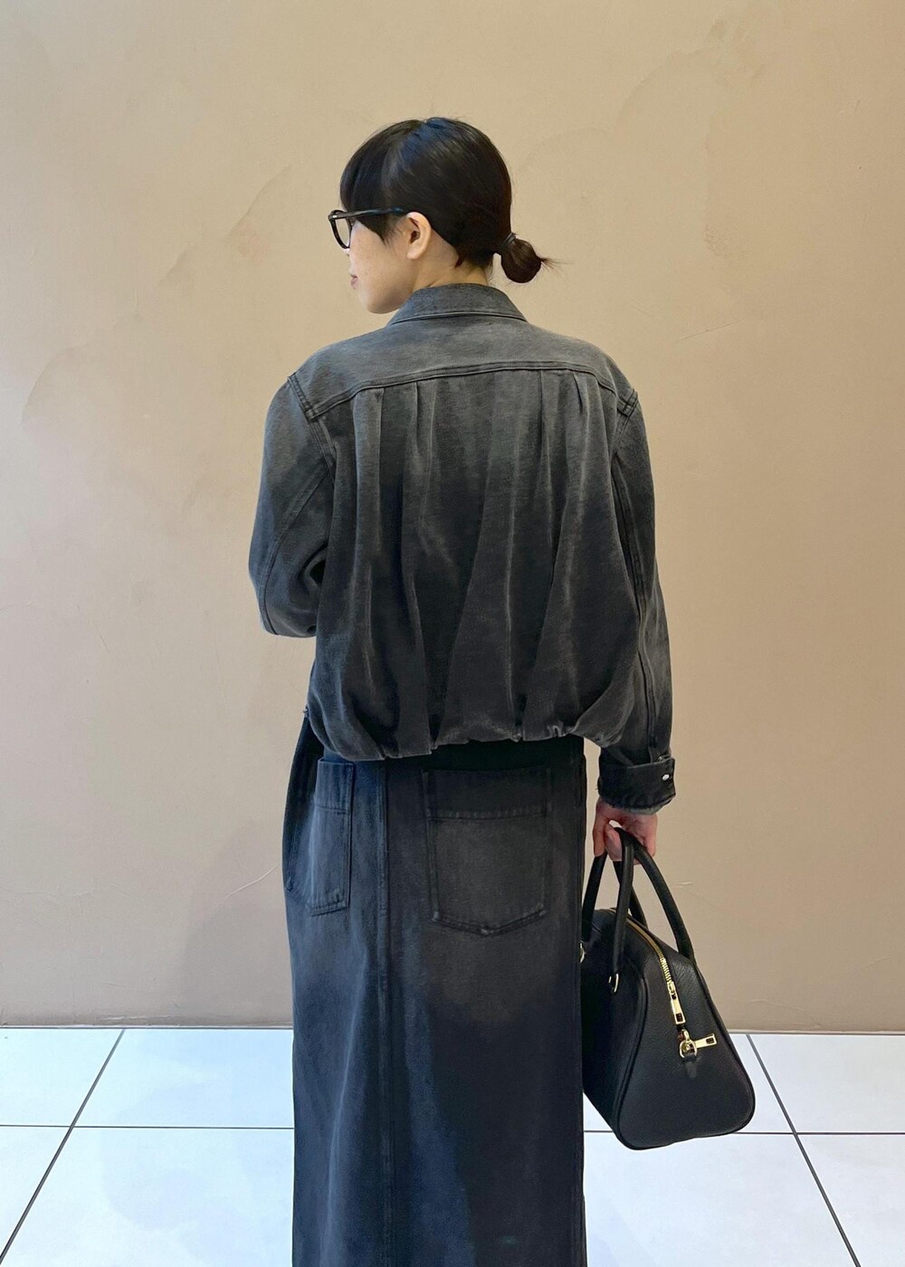 ブラック系のボストンバッグ、グレー系のデニムスカート、グレー系のデニムジャケットを着用したレディースの秋コーディネートの6枚目の写真