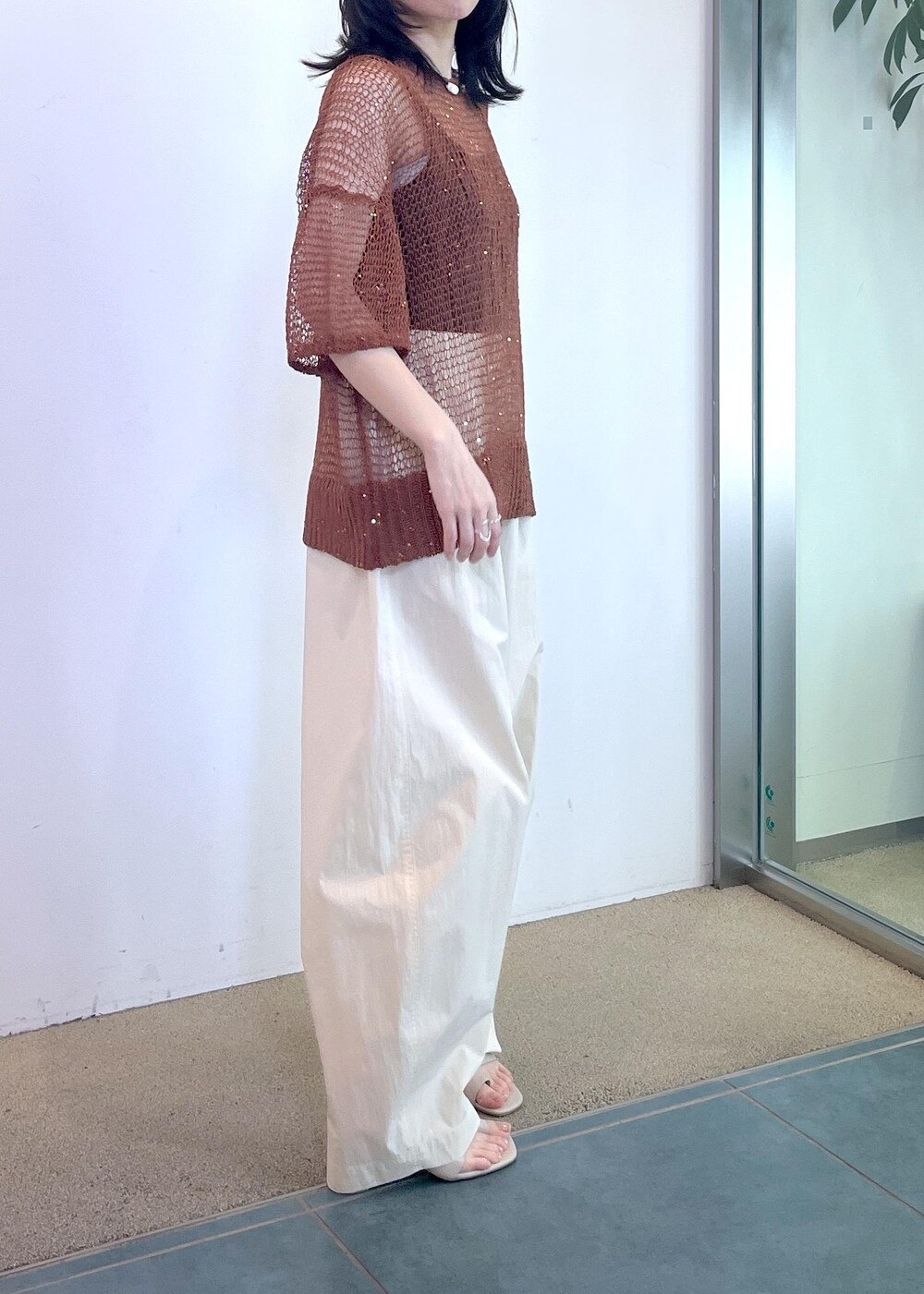 ブラック系のタンクトップ、ホワイト系のその他パンツ、ブラウン系のニット/セーターを着用したレディースの春コーディネートの4枚目の写真