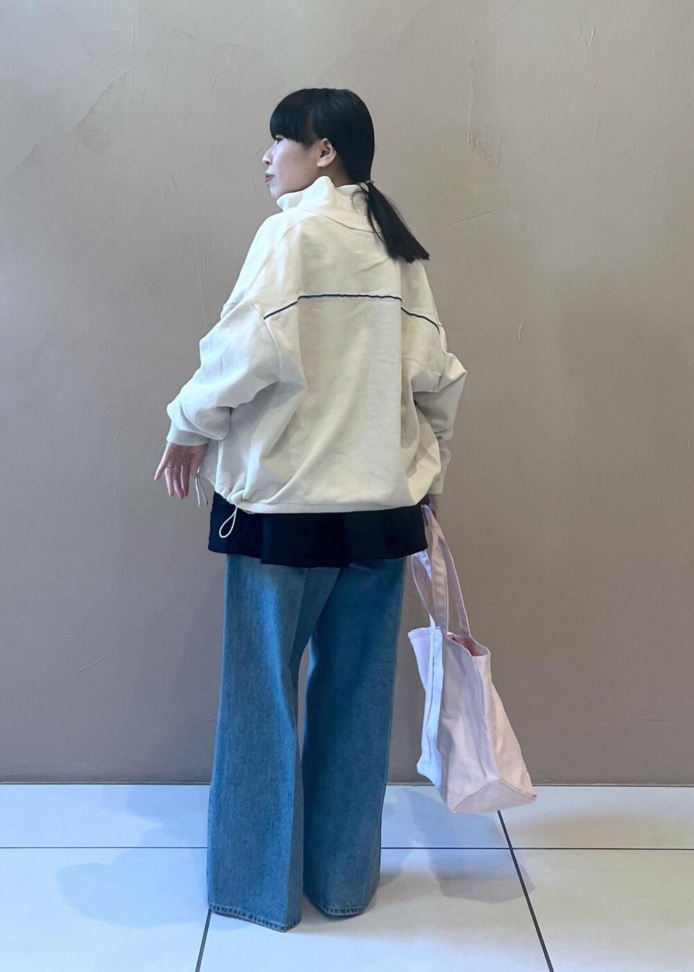 ブルー系のデニムパンツ、ブラック系のスカート、ホワイト系のタンクトップを着用したレディースの冬コーディネートの5枚目の写真