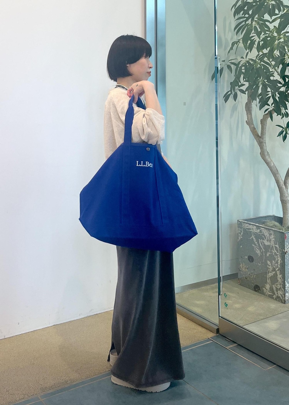 グレー系のワンピース、ホワイト系のカーディガン/ボレロを着用したレディースの夏コーディネートの2枚目の写真