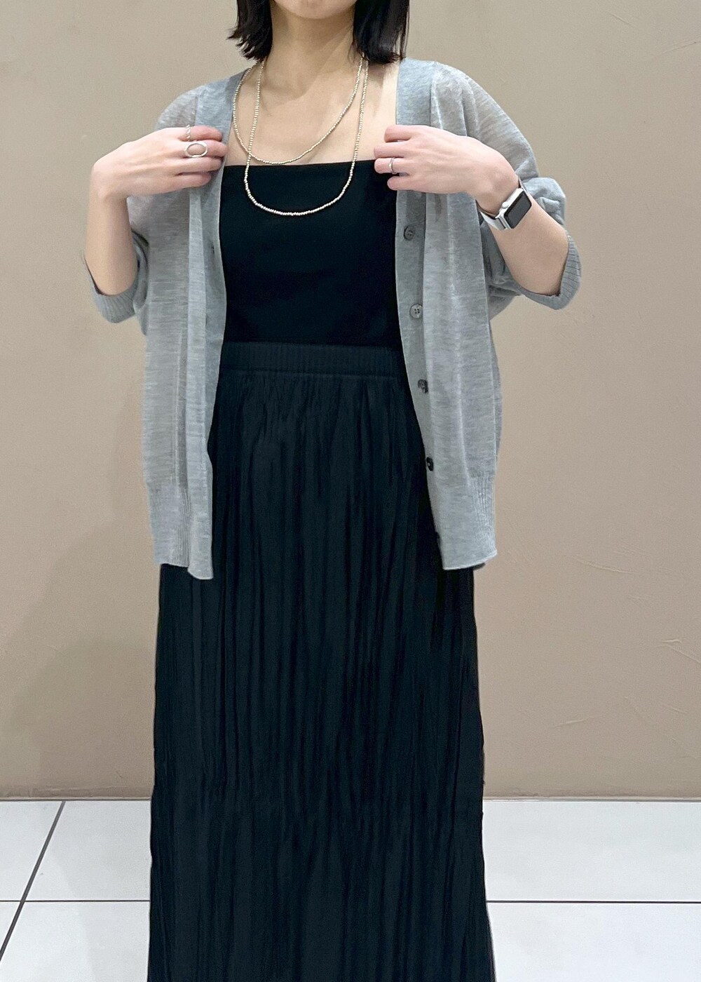 シルバー系のサンダル、ブラック系のスカート、グレー系のカーディガン/ボレロを着用したレディースの春コーディネートの5枚目の写真