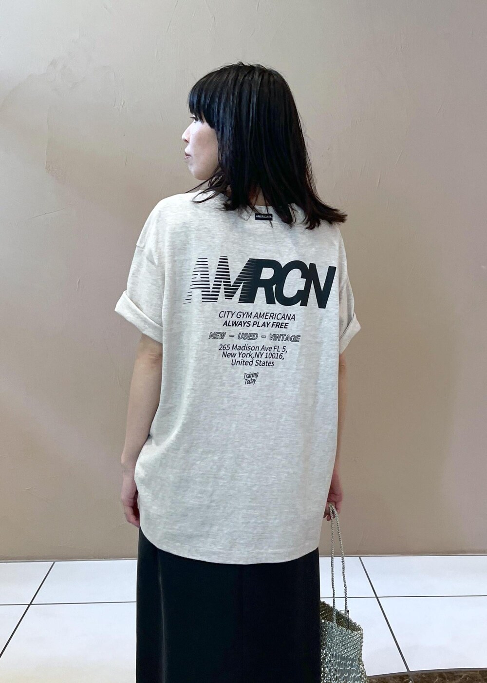 ブラック系のワンピース、ホワイト系のTシャツ/カットソー、シルバー系のトートバッグを着用したレディースの春コーディネートの7枚目の写真