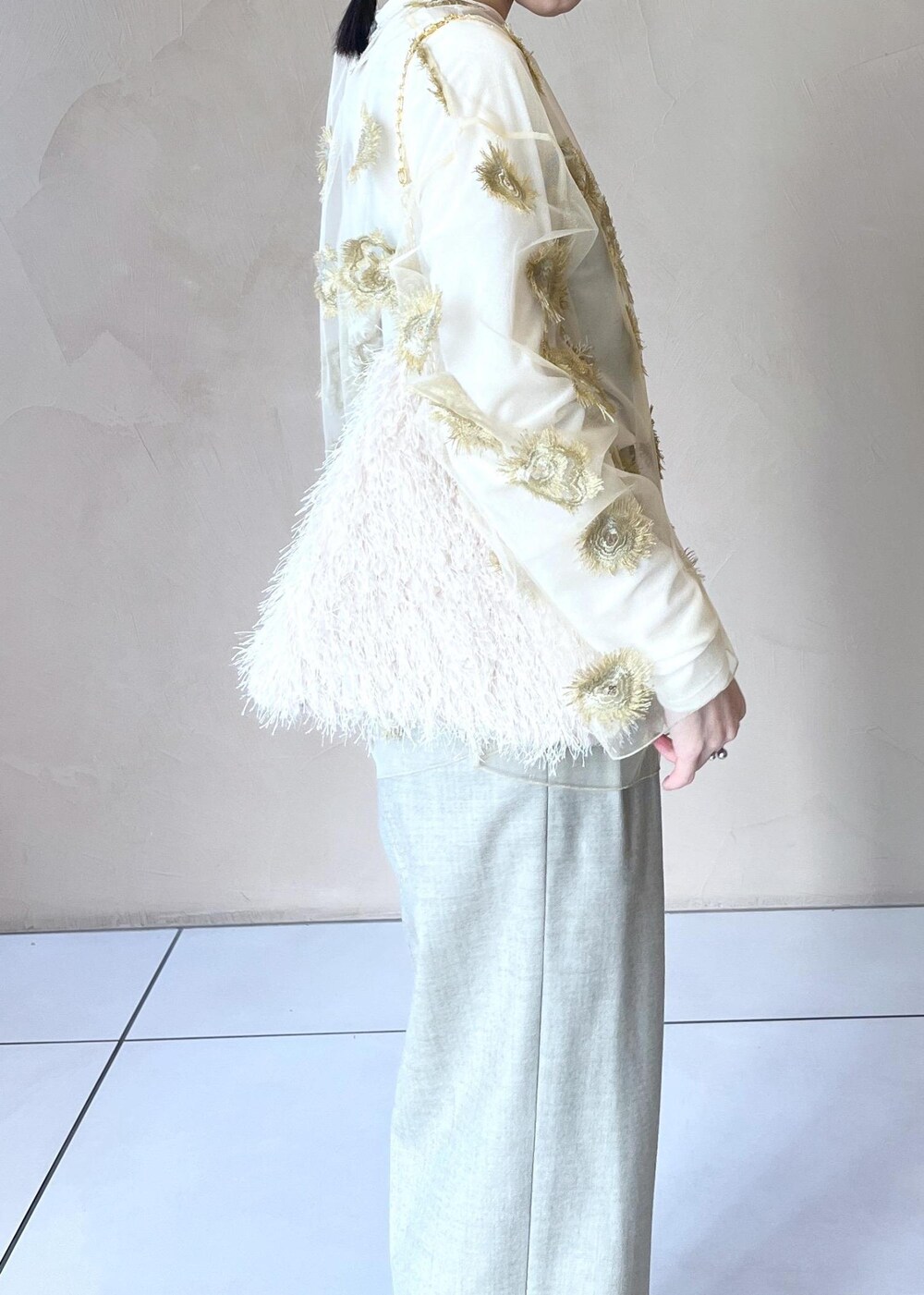 ゴールド系のTシャツ/カットソー、ホワイト系のTシャツ/カットソー、ベージュ系のスラックスを着用したレディースの冬コーディネートの4枚目の写真