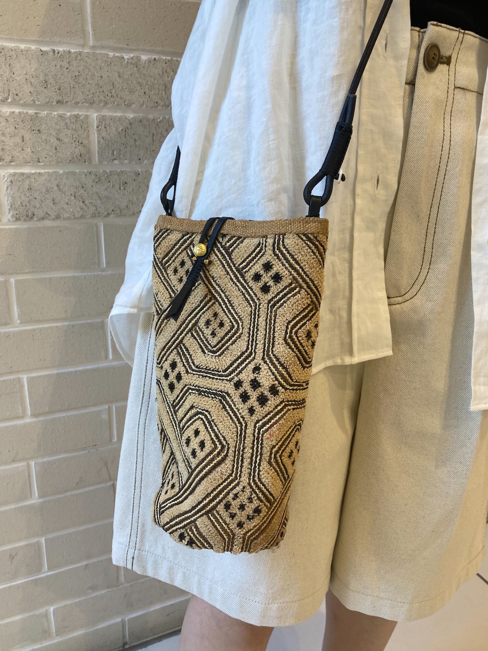 ホワイト系のシャツ/ブラウス、ホワイト系のデニムパンツ、ホワイト系のサンダルを着用したレディースの春コーディネートの5枚目の写真