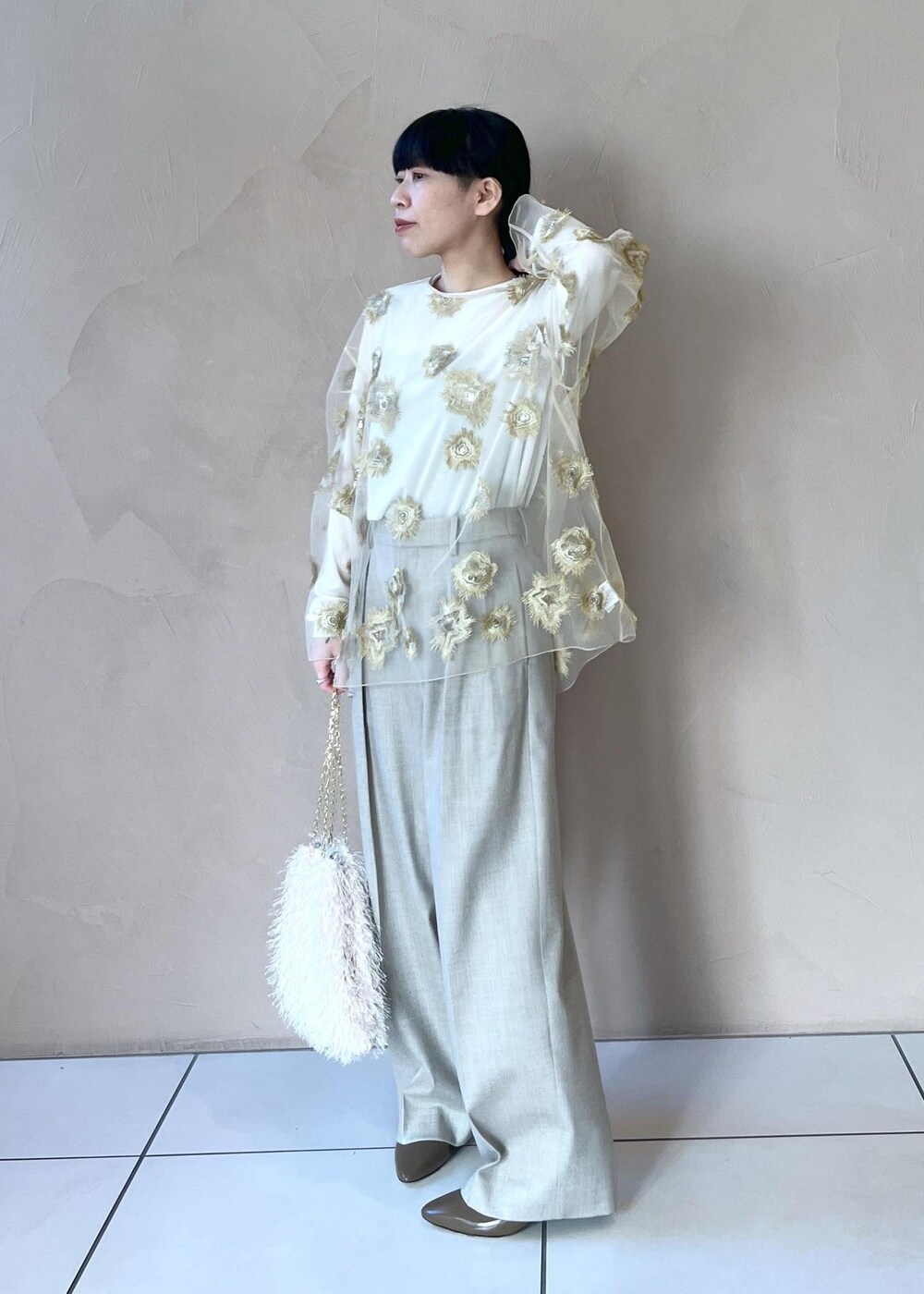 ゴールド系のTシャツ/カットソー、ホワイト系のTシャツ/カットソー、ベージュ系のスラックスを着用したレディースの冬コーディネートの2枚目の写真