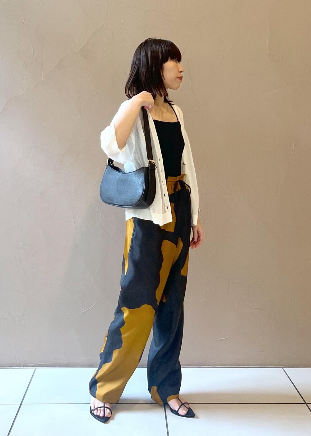 ホワイト系のカーディガン/ボレロ、ブラック系のショルダーバッグを着用したレディースの夏コーディネートの2枚目の写真