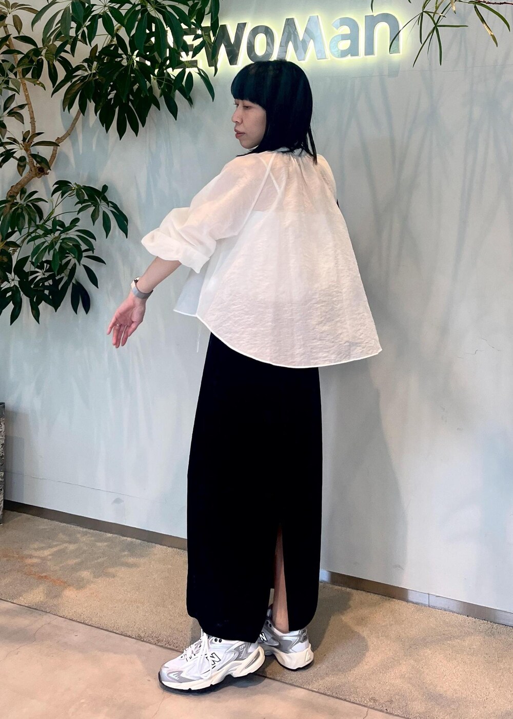 ブラック系のスカート、グリーン系のショルダーバッグ、ホワイト系のシャツ/ブラウスを着用したレディースの夏コーディネートの6枚目の写真