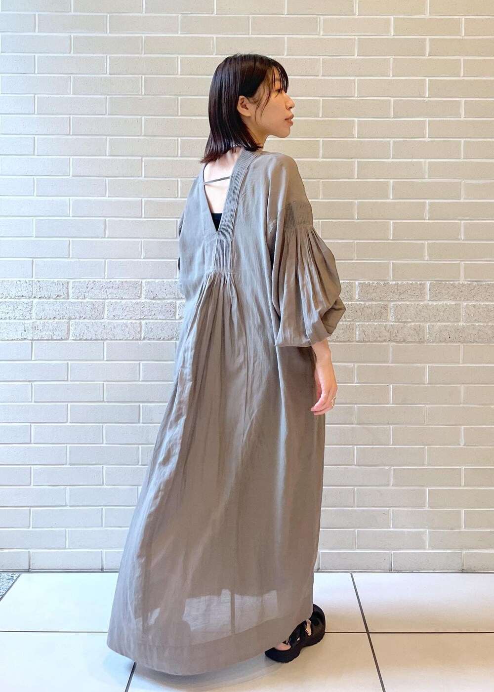 グレー系のワンピースを着用したレディースの夏コーディネートの2枚目の写真