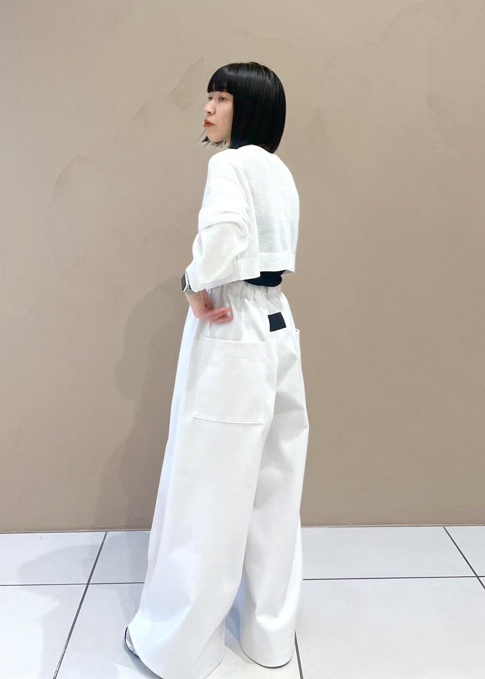 ホワイト系のニット/セーター、ブラック系のボディバッグ/ウエストポーチを着用したレディースの春コーディネートの4枚目の写真