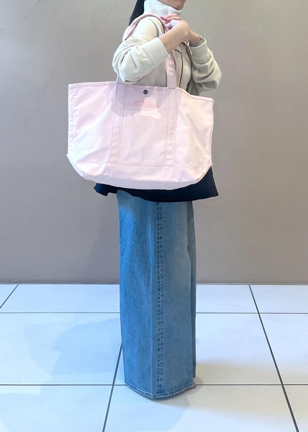 ブルー系のデニムパンツ、ブラック系のスカート、ホワイト系のタンクトップを着用したレディースの冬コーディネートの6枚目の写真