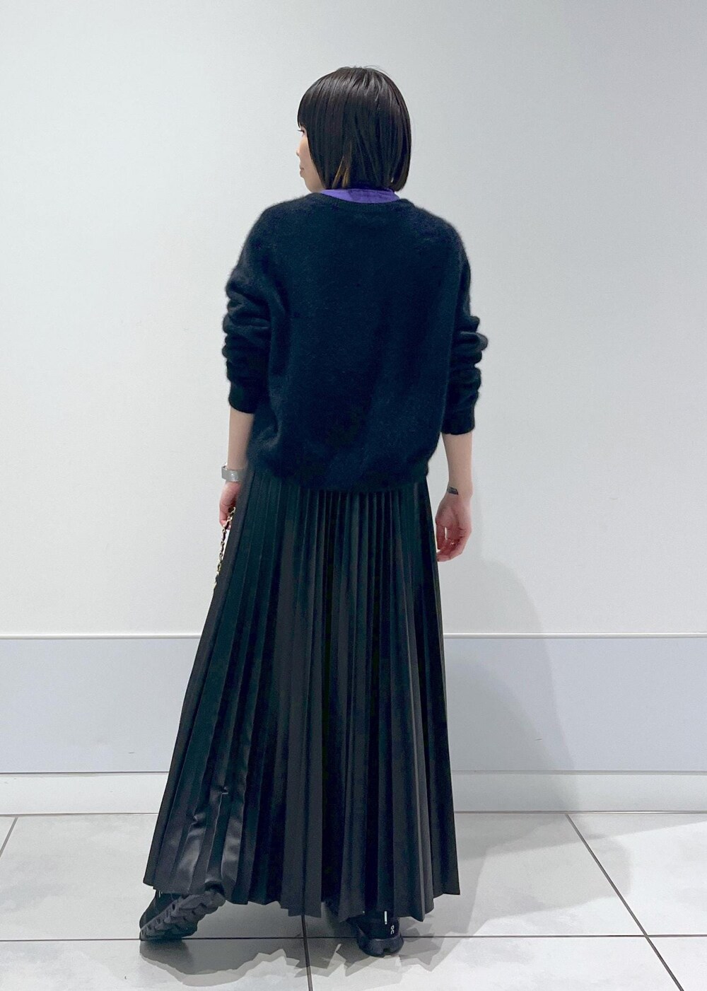 ブラック系のショルダーバッグ、ブラック系のカーディガン/ボレロ、パープル系のTシャツ/カットソーを着用したレディースの秋コーディネートの5枚目の写真