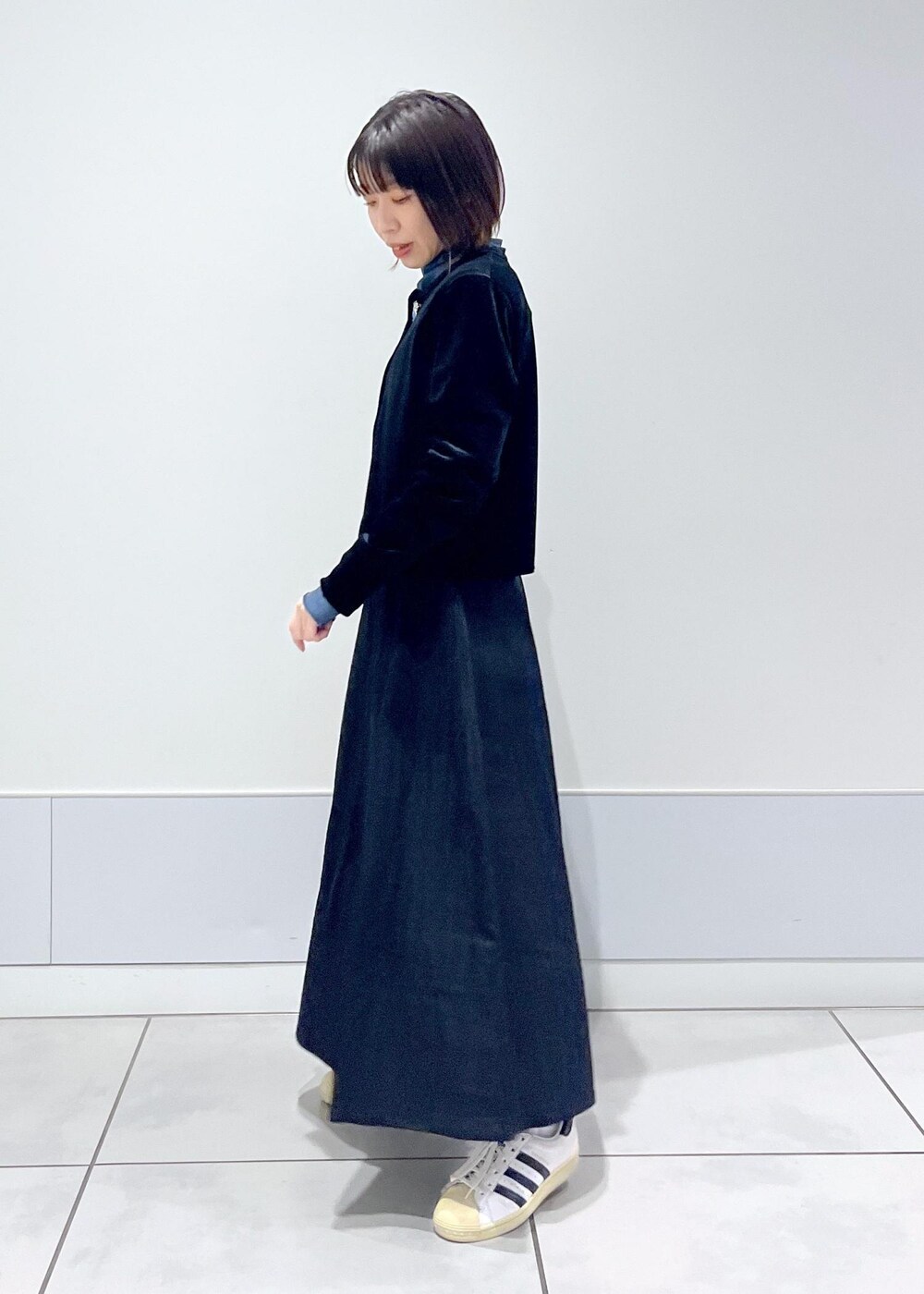 ブルー系のTシャツ/カットソー、ブラック系のスカート、ブラック系のカーディガン/ボレロを着用したレディースの冬コーディネートの3枚目の写真