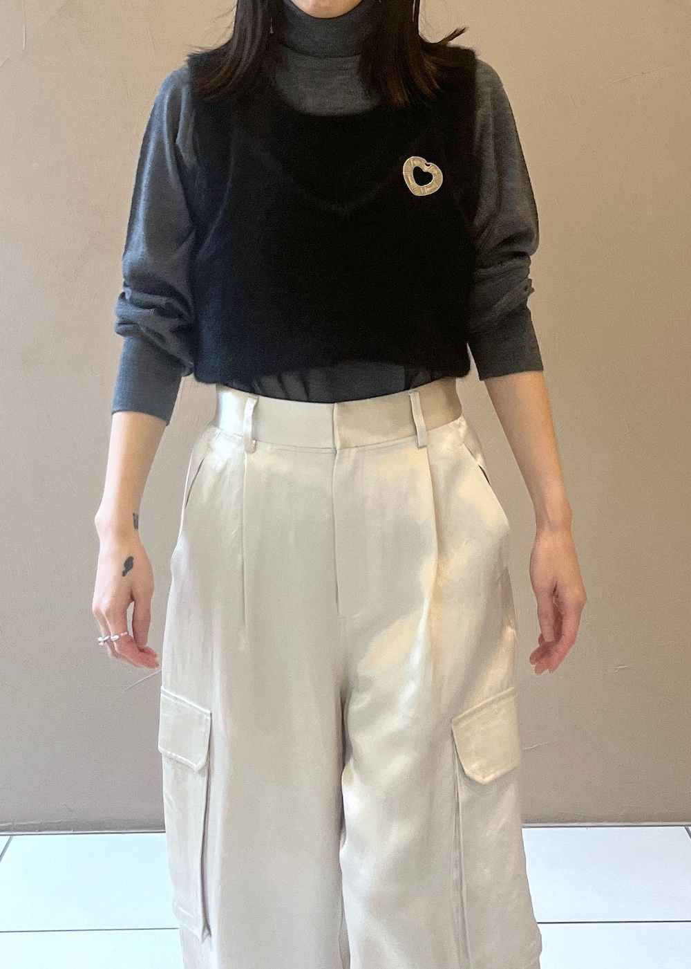 ホワイト系のカーゴパンツ、ブラック系のタンクトップ、グレー系のニット/セーターを着用したレディースの秋コーディネートの5枚目の写真