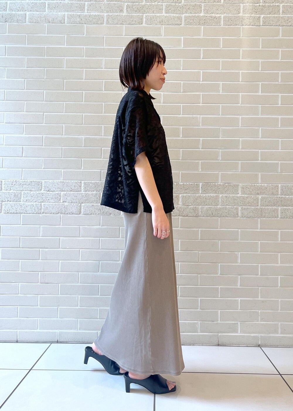 ブラック系のサンダル、ブラック系のシャツ/ブラウス、ホワイト系のタンクトップを着用したレディースの春コーディネートの3枚目の写真