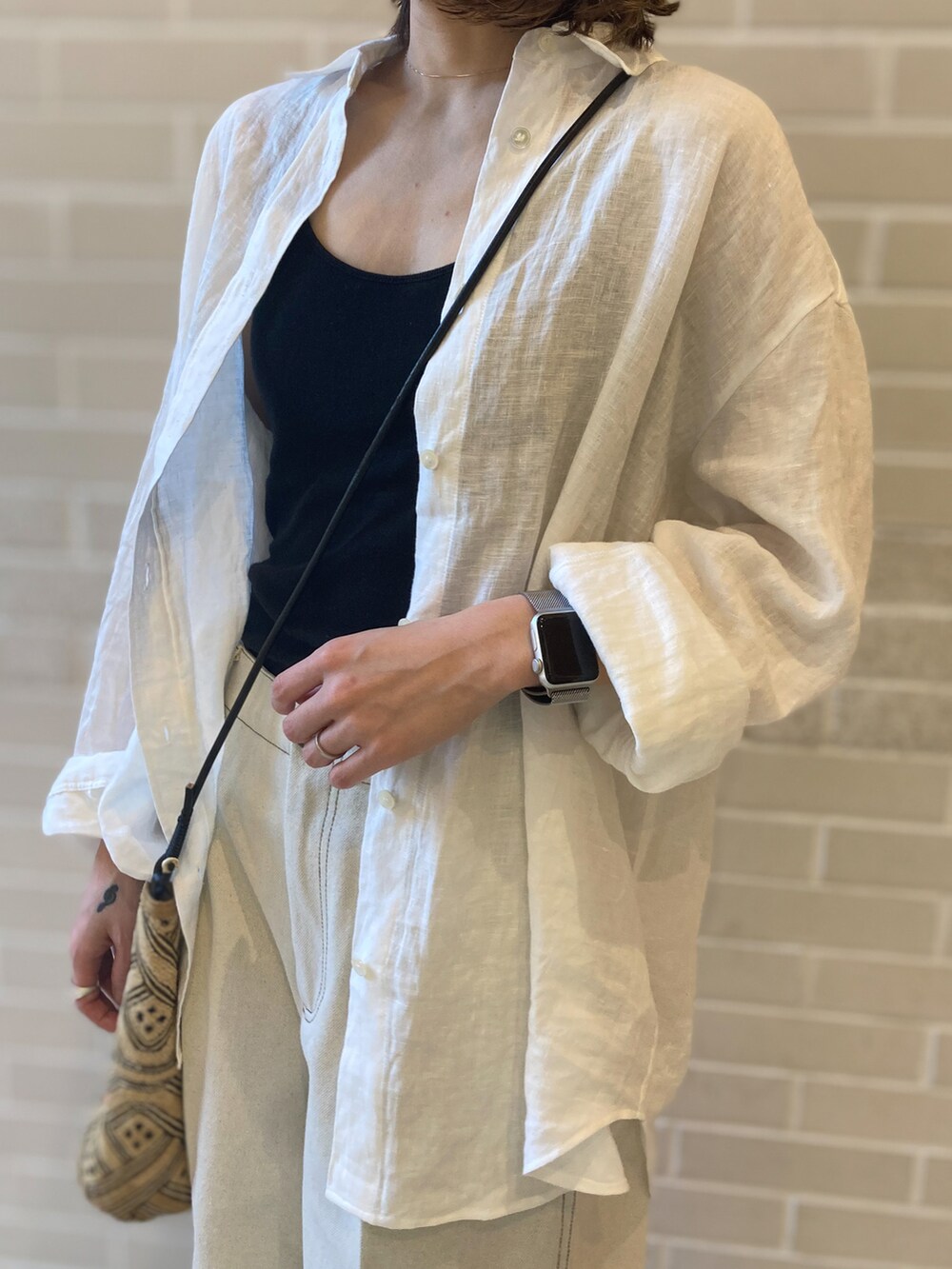 ホワイト系のシャツ/ブラウス、ホワイト系のデニムパンツ、ホワイト系のサンダルを着用したレディースの春コーディネートの3枚目の写真