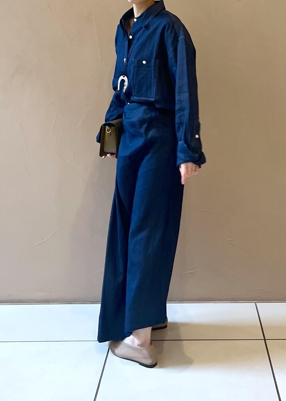 ブラウン系のショルダーバッグ、ベージュ系のパンプス、ブルー系のシャツ/ブラウスを着用したレディースの冬コーディネートの4枚目の写真