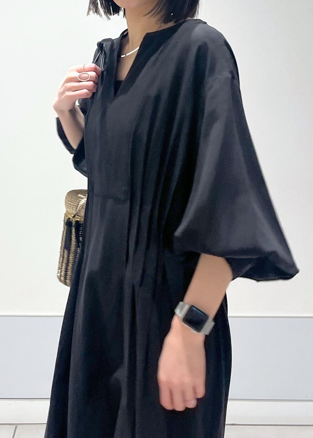 ブラック系のワンピース、ブラック系のサンダル、ホワイト系のショルダーバッグを着用したレディースの春コーディネートの5枚目の写真