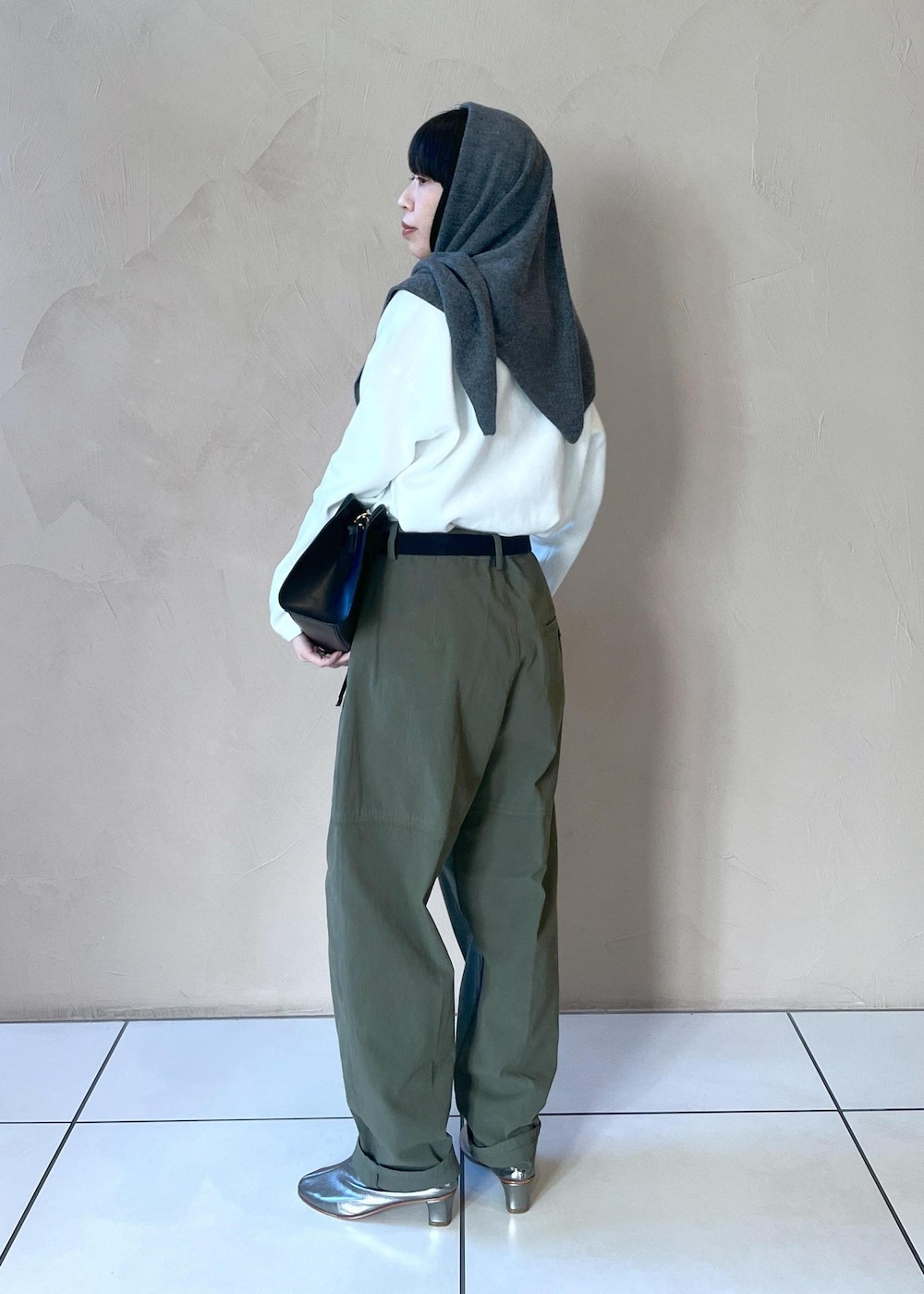 ブラック系のショルダーバッグ、ホワイト系のニット/セーター、グリーン系のその他パンツを着用したレディースの冬コーディネートの2枚目の写真