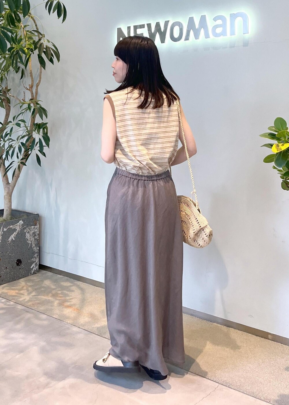 ベージュ系のサンダル、グレー系のスカート、ゴールド系のカーディガン/ボレロを着用したレディースの春コーディネートの8枚目の写真