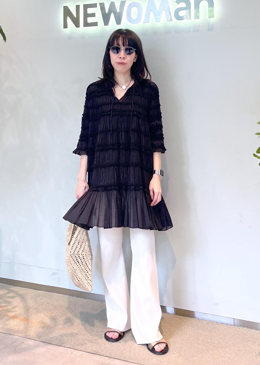 ベージュ系のその他パンツ、ホワイト系のかごバッグを着用したレディースの春コーディネートの2枚目の写真