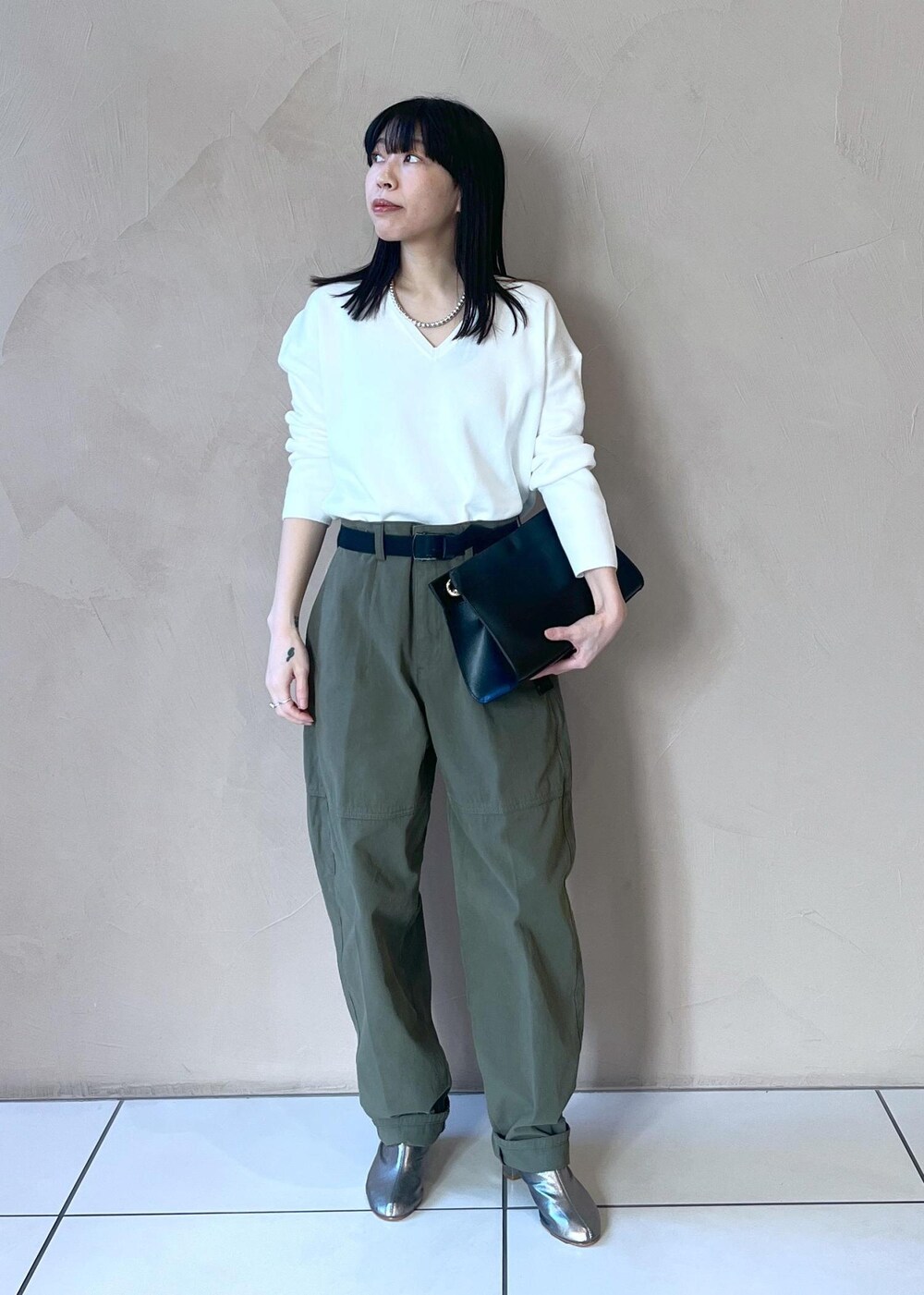 ブラック系のショルダーバッグ、ホワイト系のニット/セーター、グリーン系のその他パンツを着用したレディースの冬コーディネートの4枚目の写真