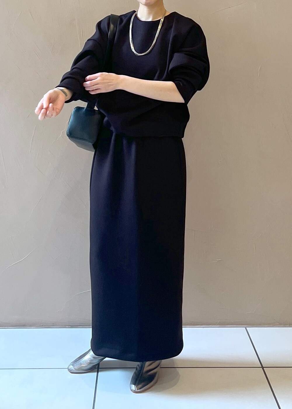 ブラック系のショルダーバッグ、ブラック系のスカート、ブラック系のTシャツ/カットソーを着用したレディースの秋コーディネートの5枚目の写真