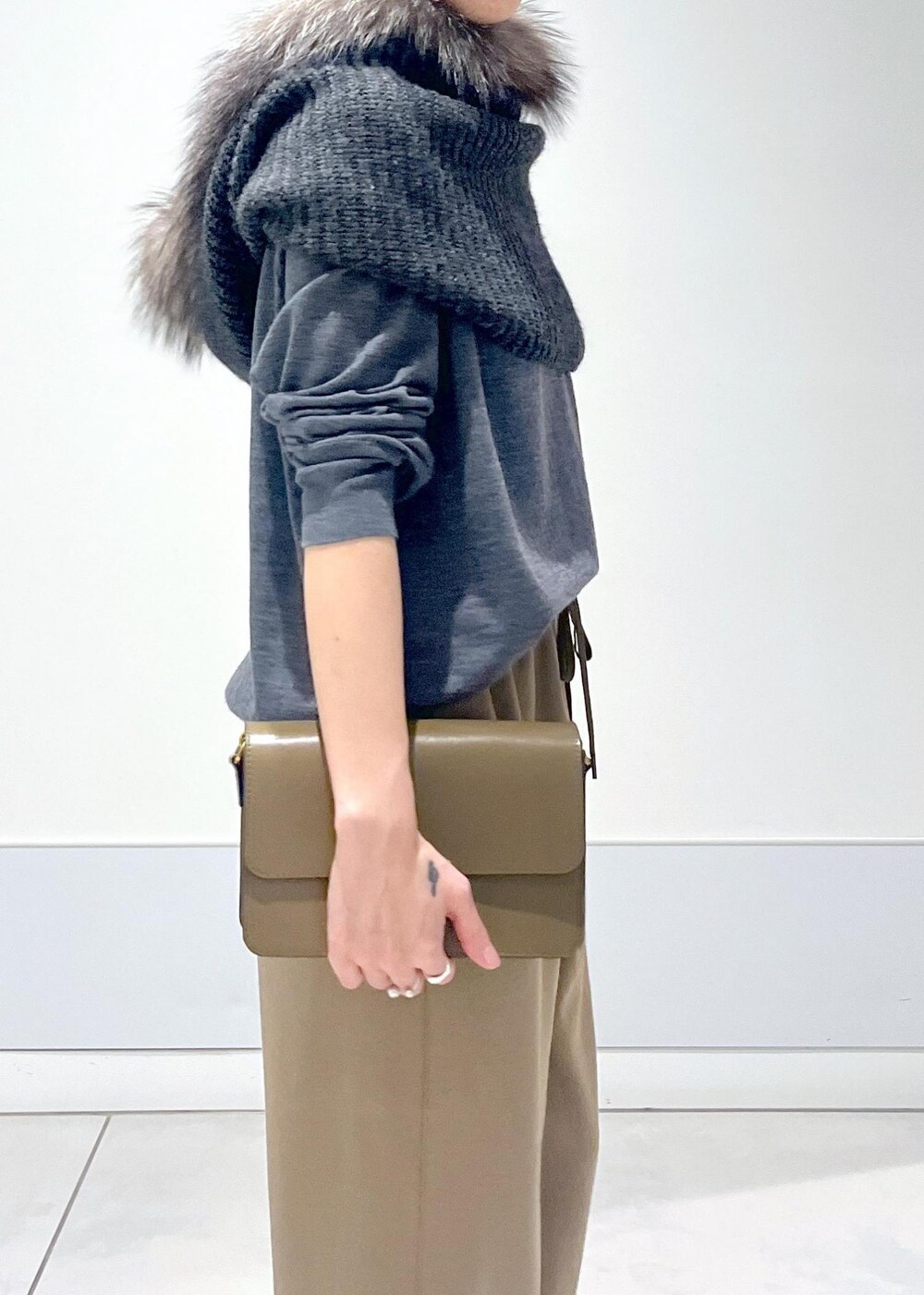 ブラウン系のショルダーバッグ、グレー系のニット/セーター、イエロー系のその他パンツを着用したレディースの秋コーディネートの8枚目の写真