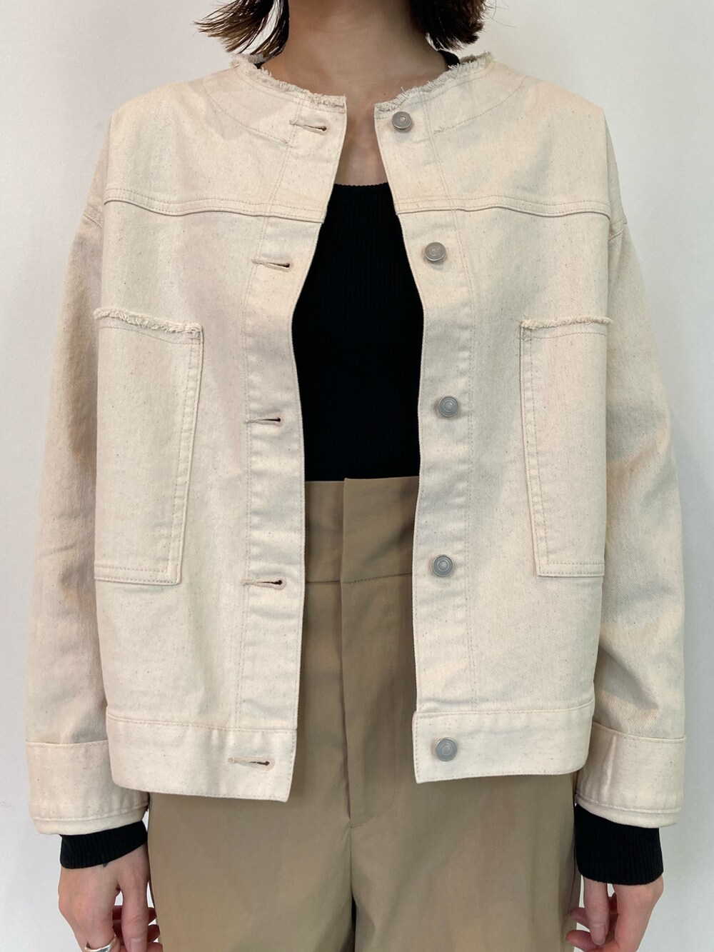 ブラック系のニット/セーター、ホワイト系のブルゾン、ベージュ系のその他パンツを着用したレディースの春コーディネートの4枚目の写真