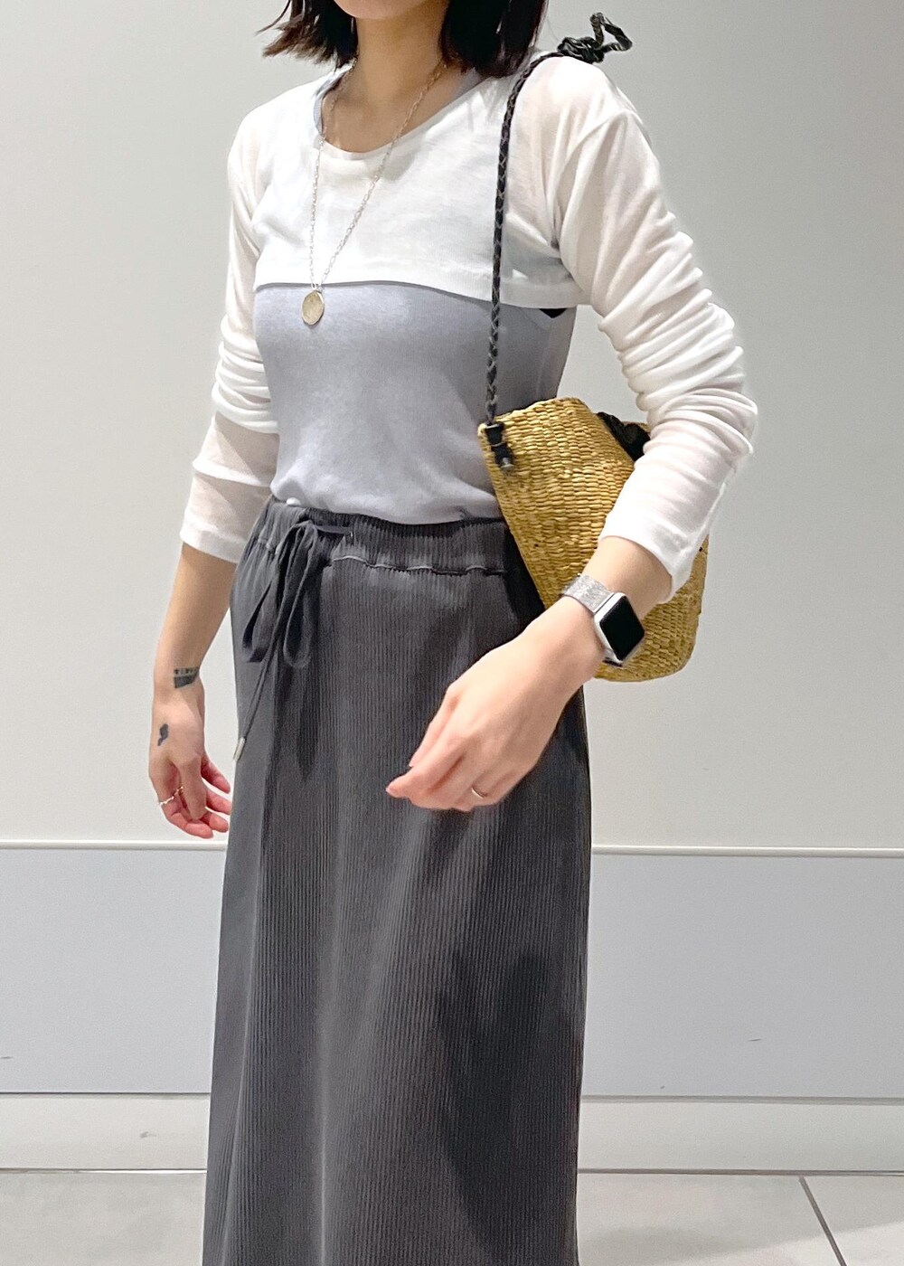 ベージュ系のかごバッグ、グレー系のスカート、グレー系のタンクトップを着用したレディースの夏コーディネートの6枚目の写真