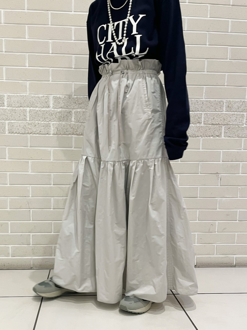 ブルー系のTシャツ/カットソー、グレー系のスカート、グリーン系のスニーカーを着用したレディースの冬コーディネートの5枚目の写真