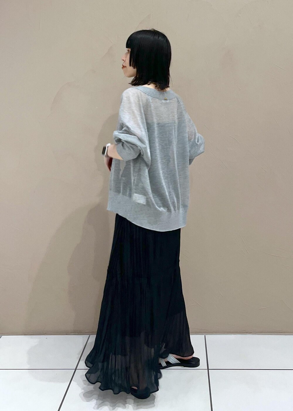 シルバー系のサンダル、ブラック系のスカート、グレー系のカーディガン/ボレロを着用したレディースの春コーディネートの3枚目の写真