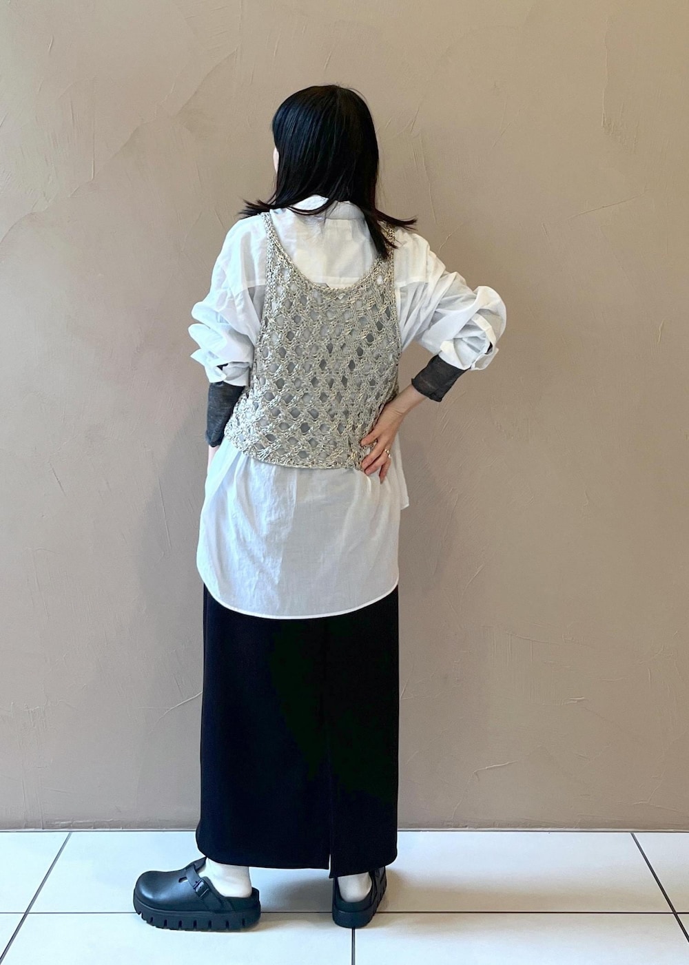 ブラック系のスカート、シルバー系のベスト、ホワイト系のシャツ/ブラウスを着用したレディースの秋コーディネートの2枚目の写真