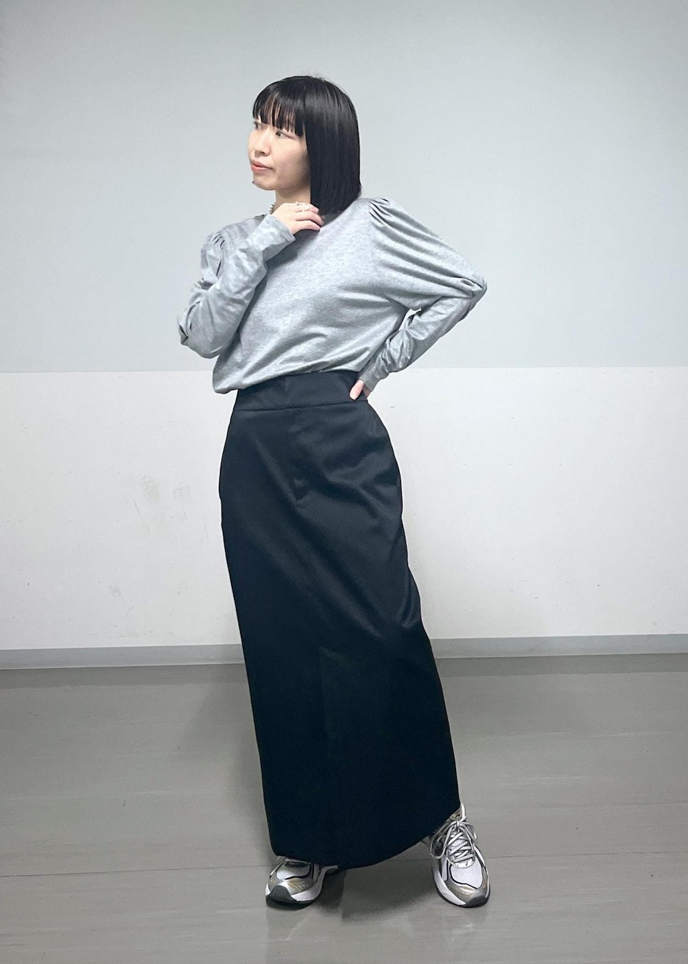 ブラック系のスカート、グレー系のTシャツ/カットソーを着用したレディースの春コーディネートの2枚目の写真