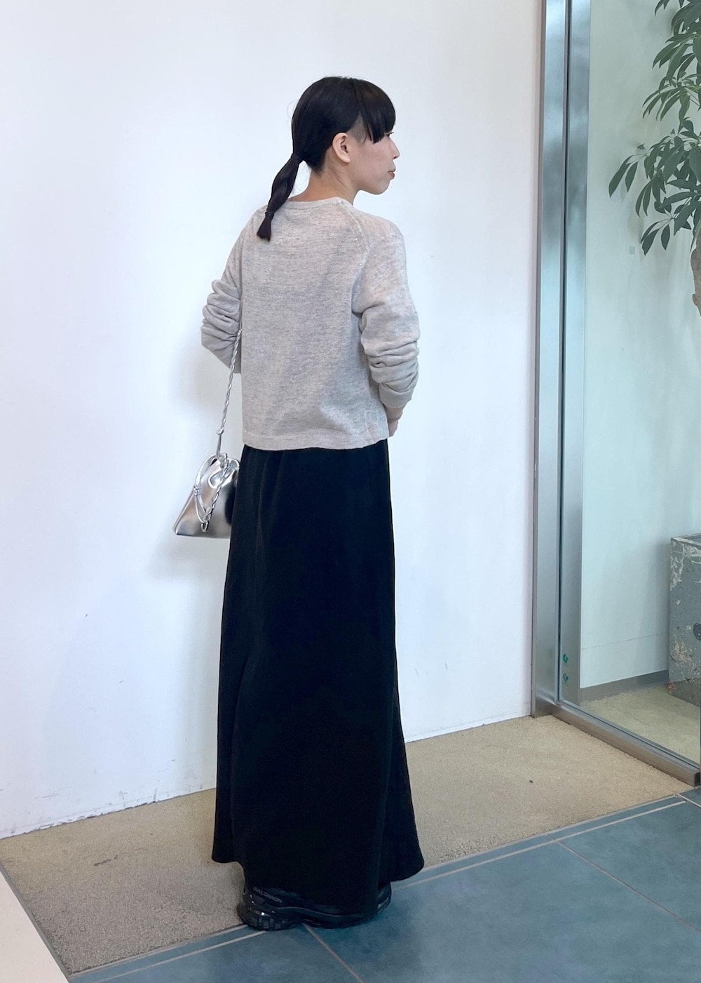 グレー系のカーディガン/ボレロ、ブラック系のスカート、シルバー系のショルダーバッグを着用したレディースの春コーディネートの3枚目の写真