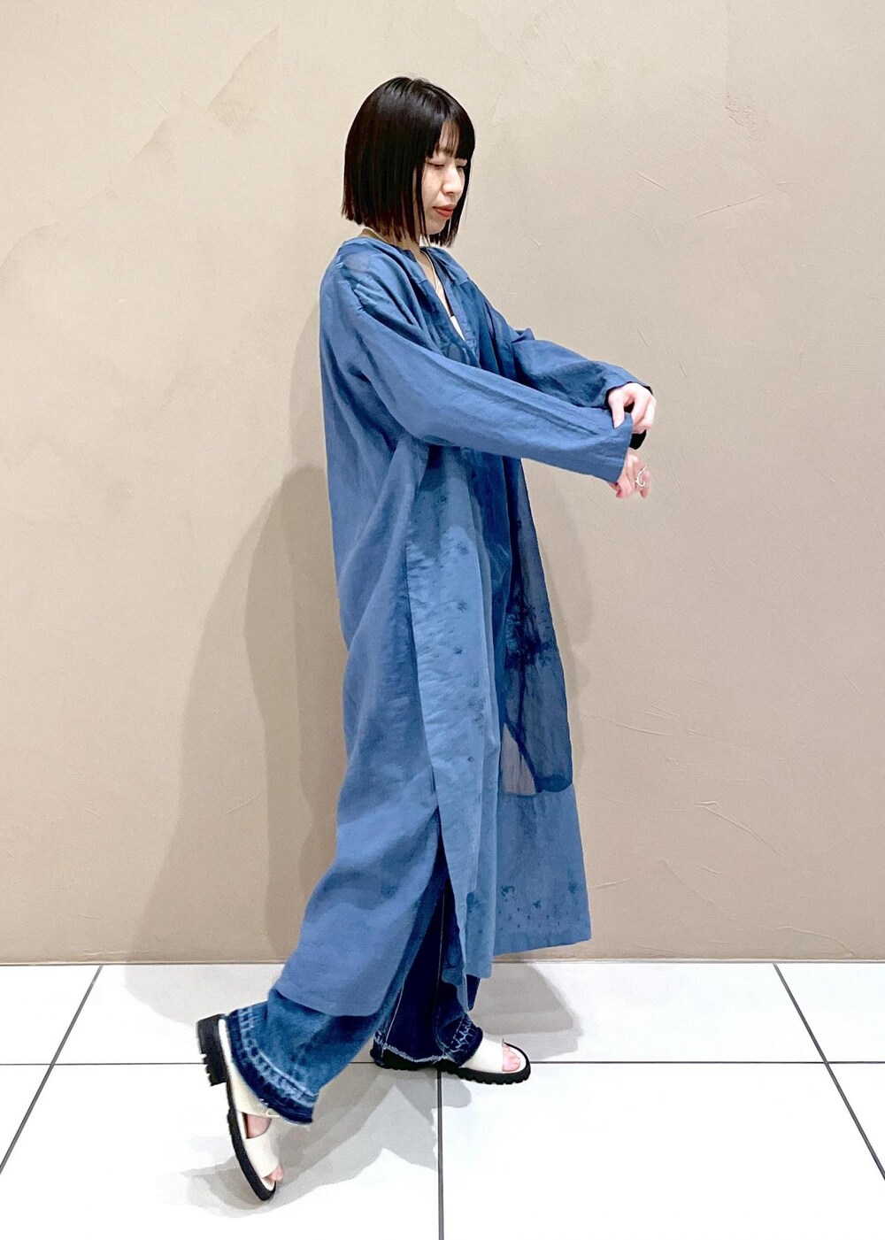 ブルー系のデニムパンツ、ホワイト系のかごバッグを着用したレディースの春コーディネートの2枚目の写真