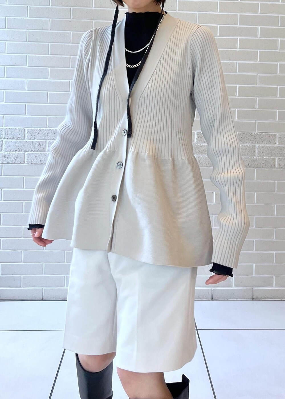 ブラック系のブーツ、ホワイト系のその他パンツ、グレー系のカーディガン/ボレロを着用したレディースの秋コーディネートの4枚目の写真