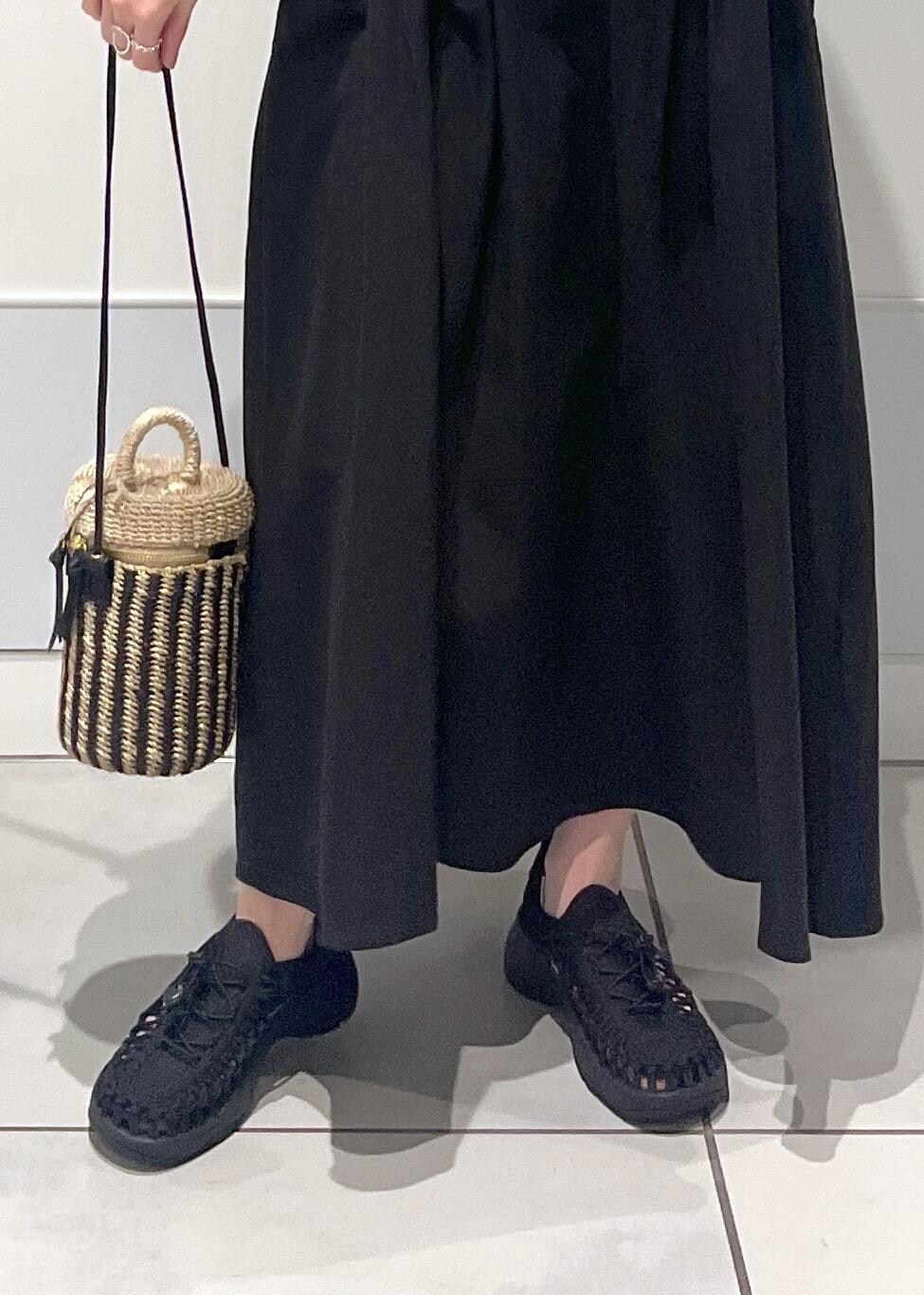 ブラック系のワンピース、ブラック系のサンダル、ホワイト系のショルダーバッグを着用したレディースの春コーディネートの6枚目の写真