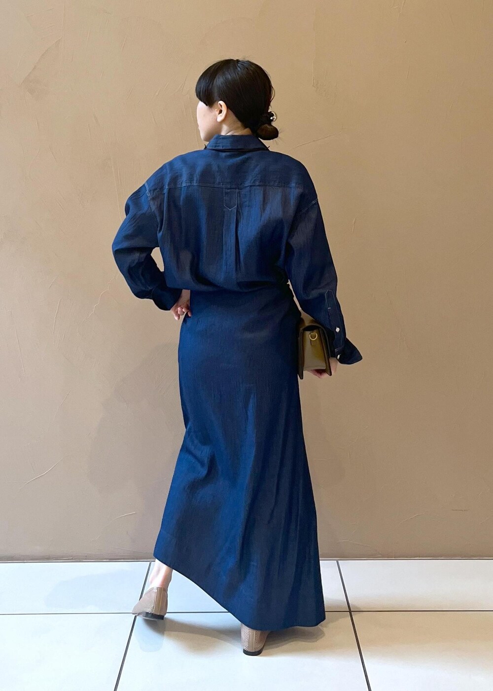 ブラウン系のショルダーバッグ、ベージュ系のパンプス、ブルー系のシャツ/ブラウスを着用したレディースの冬コーディネートの2枚目の写真