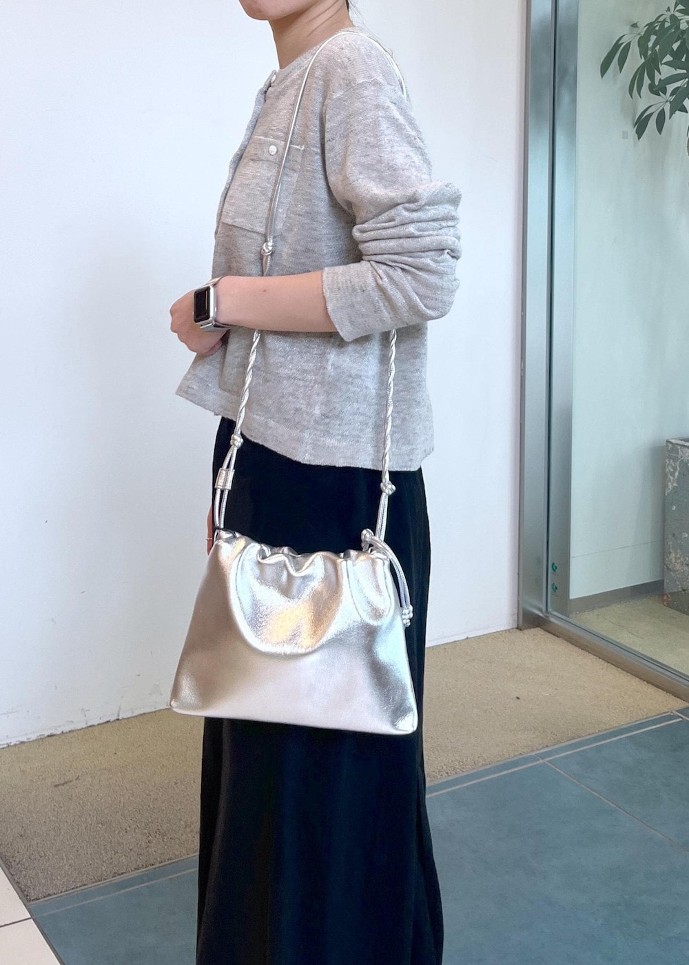 グレー系のカーディガン/ボレロ、ブラック系のスカート、シルバー系のショルダーバッグを着用したレディースの春コーディネートの7枚目の写真